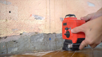 Repair, expose the laser level on the wall. Level the walls with a laser level. Installation of new tiles on the wall using a laser level