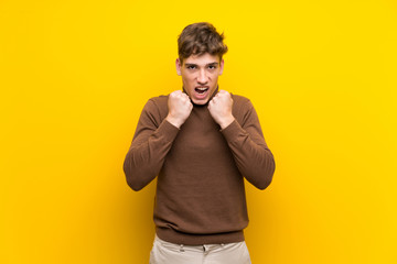 Handsome young man over isolated yellow background frustrated by a bad situation