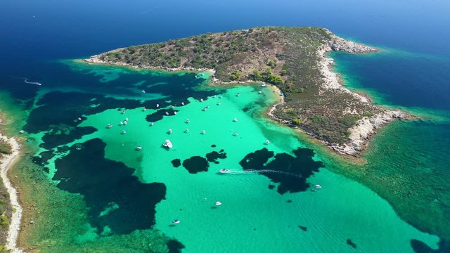 Aerial drone video of iconic exotic bay known as blue lagoon in Diaporos island with turquoise clear sea, Vourvourou, Sithonia Peninsula, Halkidiki, North Greece