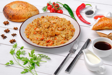 The concept of oriental cuisine. Assorted Uzbek food set, pilaf, samsa, lagman, manta, shurpa Uzbek restaurant concept, Uzbek food. Homemade Uzbek pilaf or plov from lamb served in cast iron cookware