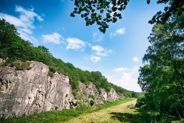 Green meadow in a valley with cliffs