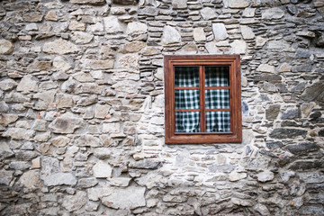 A wooden window in stone wall of old house. Copy space.