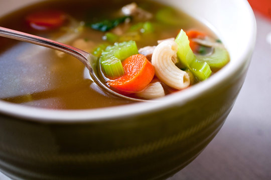 Close up of tortellini and turkey soup served in bowl