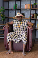 Happy Handsome african man in traditional clothes sitting on chair