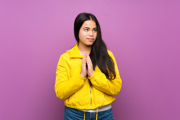 Young teenager Asian girl over isolated purple background scheming something