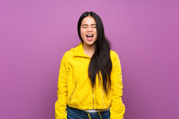 Young teenager Asian girl over isolated purple background shouting to the front with mouth wide open
