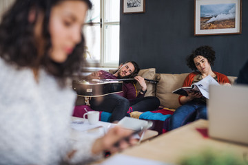 A group of young friends relaxing indoors, house sharing concept.