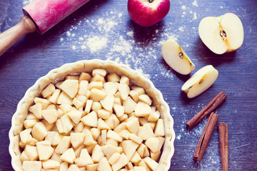 Traditional homemade apple pie and ingredients on wooden background for autumn holiday