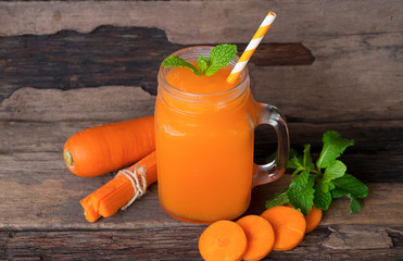 Carrot smoothie Orange Vegetables Healthy drink in a glass of morning on a wooden background.