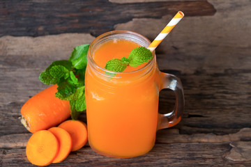 Carrot smoothie Orange Vegetables Healthy drink in a glass of morning on a wooden background.