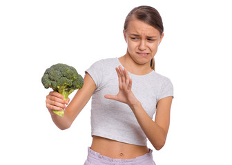 Portrait of young teen girl holding fresh green broccoli, isolated on white background. Child do...