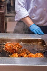 The restaurant chef grilling delicious crayfish in kitchen