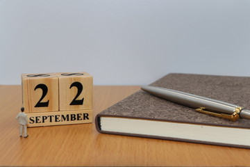 September  22, a calendar photo from the wood The table top consists of a book and pen that is...