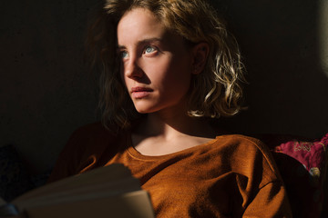 Portrait of pensive young woman with book