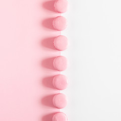 Pink macaroons on pink and white background. Sweet background. Flat lay, top view, copy space