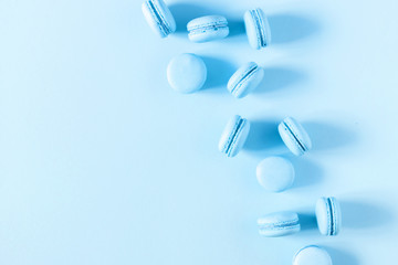 Light blue macaroons on pastel blue background. Sweet background. Flat lay, top view, copy space