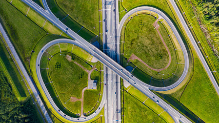 Aerial view of highway in city. Cars crossing interchange overpass. Highway interchange with traffic. Aerial bird's eye photo of highway. Expressway. Road junctions. Car passing. Top view from above.