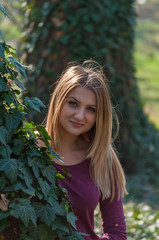 Outdoors portrait of a woman, hiding in branches of ivy