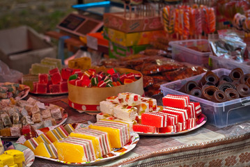Turkish national sweets are sold at the fair. Multi-colored Asian desserts stacked on the table. Rahat lokum in bulk is sold at the festival.