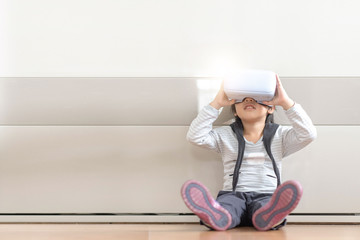asian children using virtual reality headsets while sitting on the floor