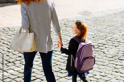 Joyful little female talking to her mommy
