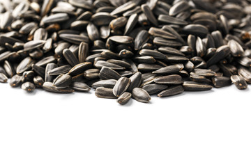 Seeds in a black shell are a bunch on a white background. In full screen