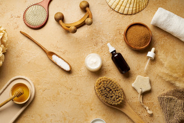 Fototapeta na wymiar Spa beauty skincare flatlay on travertine background. Body brush, serum and ingredients for scrubs. View from above, copy space