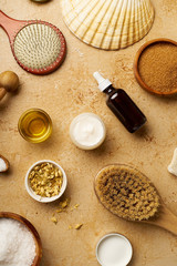 Spa beauty skincare flatlay on travertine background. Body brush, serum and ingredients for scrubs. View from above, copy space