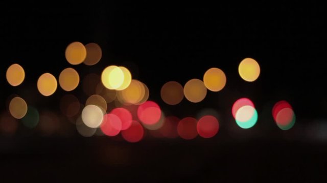 Lights of the night city background. Defocus headlights of moving cars urban traffic. Abstract bright blured colored bokeh.