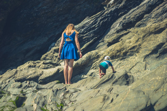 Young mother and her toddler on a rocky beach in the summer