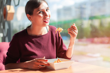Girl eating chicken nuggets with salad in a restaurant