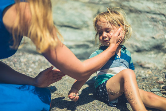 Young mother applying suncream on her toddler