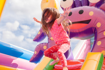 A cheerful child plays in an inflatable castle