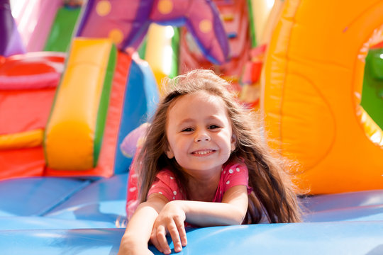 A cheerful child plays in an inflatable castle