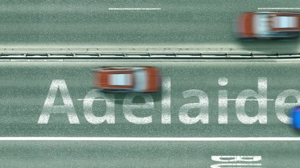 Aerial down view of the motorway with cars revealing Adelaide caption. Car travel to Australia intro clip