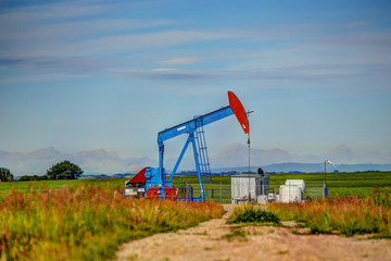 Fototapeta na wymiar Crude oil pumpjack in a field in rural Alberta