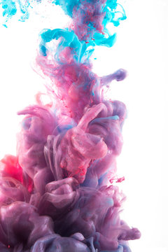 Close up of pink and blue ink dissolving in water