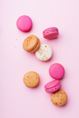 Flatlay with colorful macarons on pink background. Top view