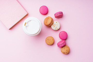 Obraz na płótnie Canvas Flatlay with colorful macarons on pink background. Top view, space for text