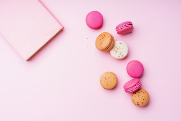 Flatlay with colorful macarons on pink background. Top view, space for text