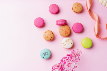Flatlay with colorful macarons on pink background. Top view