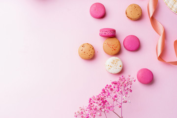 Fototapeta na wymiar Flatlay with colorful macarons on pink background. Top view