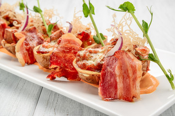 Potato skin with bacon and cheese, tomato sauce