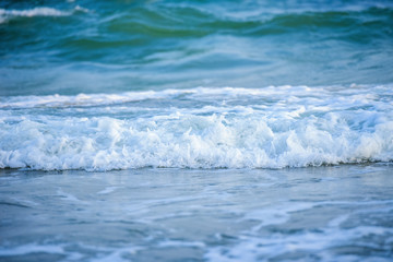 White wave of blue sea on sandy beach.