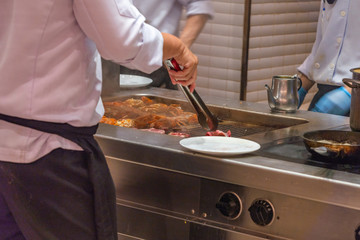 The cooking chef preparing grilled lobsters on electric stove