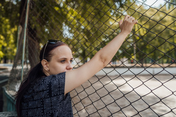 The woman's hands are gripping the bars. The hands on the lattice are symbolize limitation in...