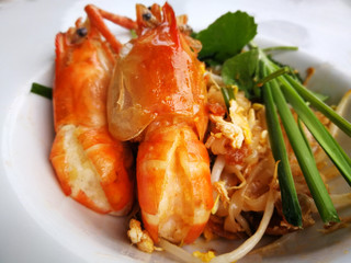 Asian rice noodles, Thailand's national dishes with big shrimps and vegetables close-up on the table, Stir-fried noodles with egg. Thai call 