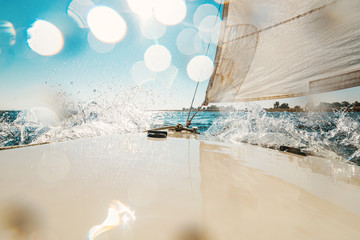 Water splashes on the deck of a small sailing boat