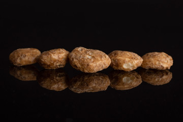 Group of five whole chocolate ball breakfast cereals isolated on black glass