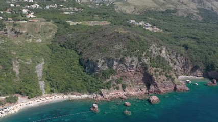 Drone flies above the coastline of the Adriatic sea, southern Montenegro, in a sunny summer day. Water in the sea is turquoise, clean and clear
